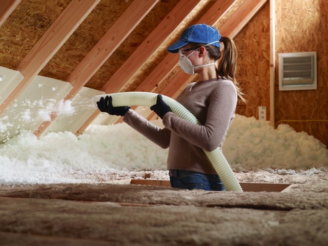 Woman insulating attic in central New Mexico
