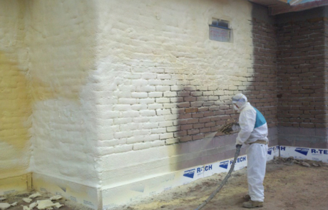 Exterior of a building being sprayed with spray foam insulation in central New Mexico